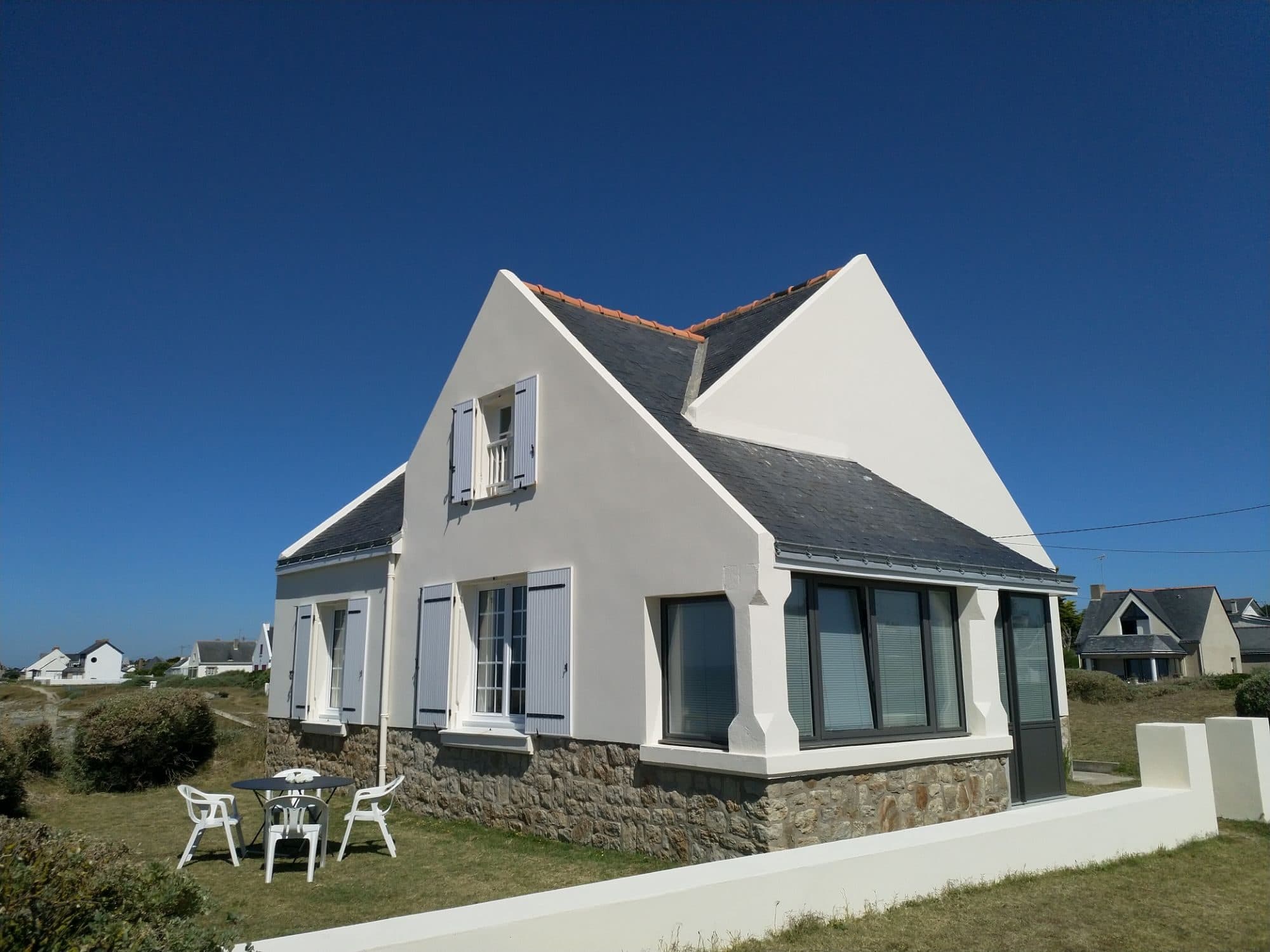 La maison, son terrain et son salon de jardin sous le soleil